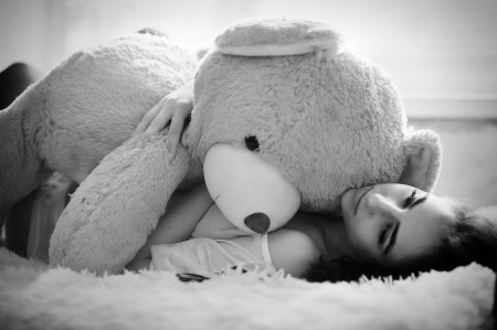 Девушка лежит с плюшевым мишкой