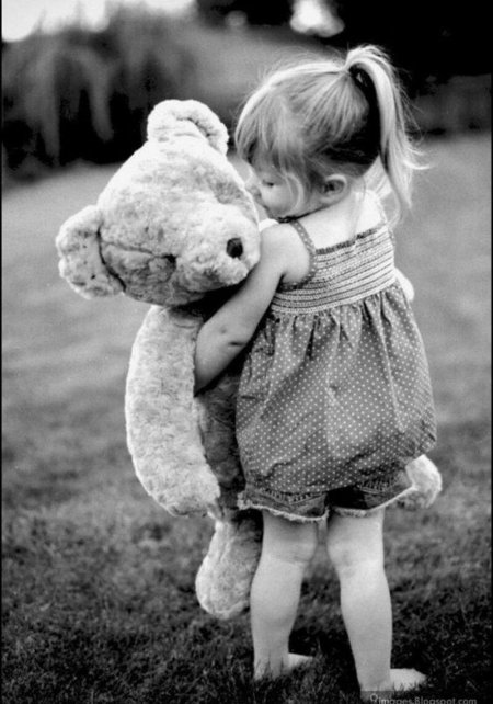 Девочка обнимает плюшевого мишку