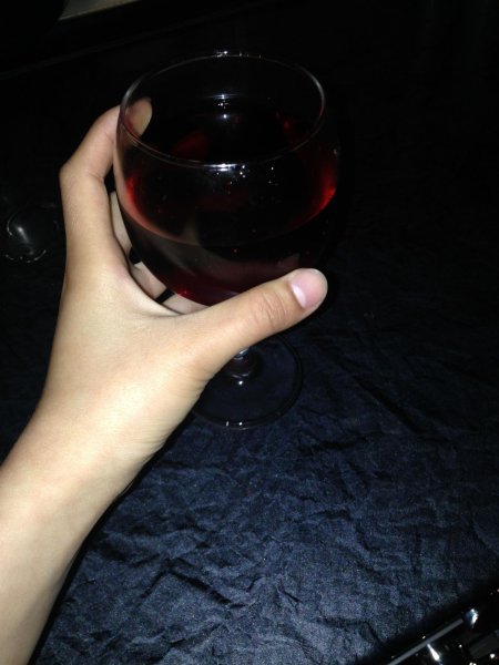 Бокал вина в руке девушки дома