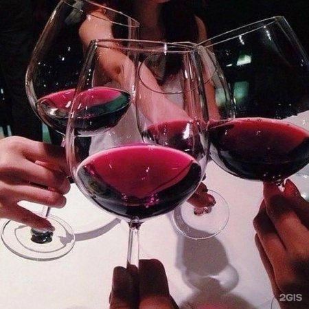 Бокал вина в руке девушки дома