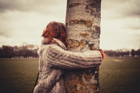 Девушка обнимает дерево