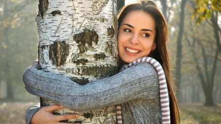 Девушка обнимает дерево