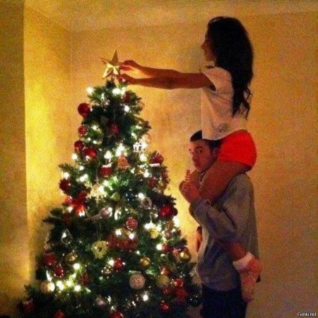 Девушка наряжает елку