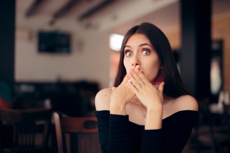 Женщина закрывает рот рукой