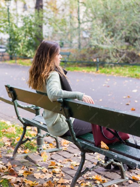 Девушка сидит на скамье
