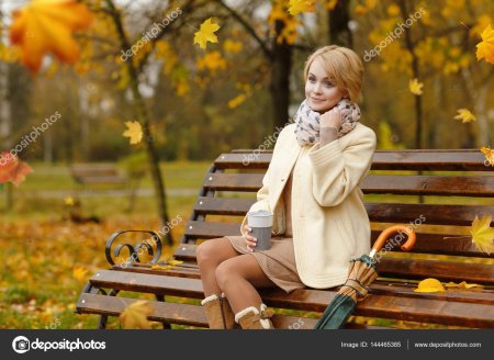 Женщина на скамейке в парке осенью