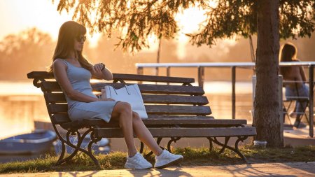 Женщина сидит на скамейке