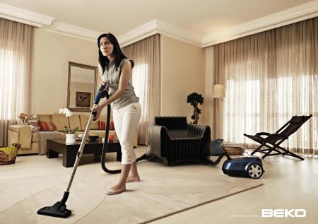 Женщина пылесосит