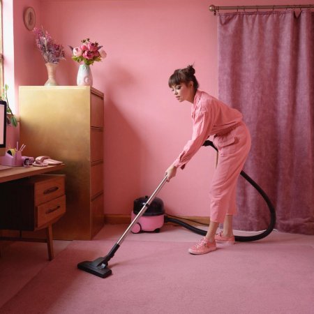 Женщина пылесосит
