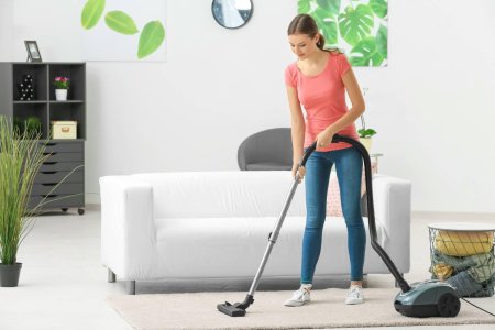 Девушка пылесосит