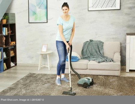 Женщина пылесосит