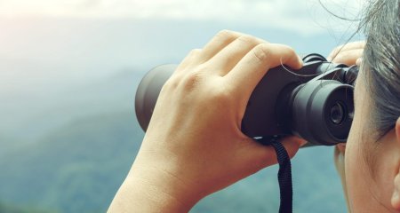 Девушка смотрит в бинокль