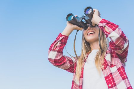 Женщина смотрит в бинокль