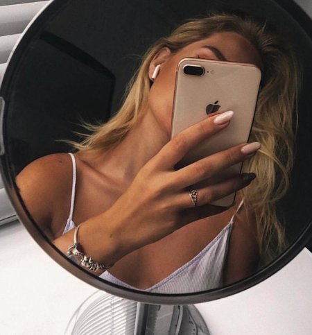 Девушка с айфоном в зеркале