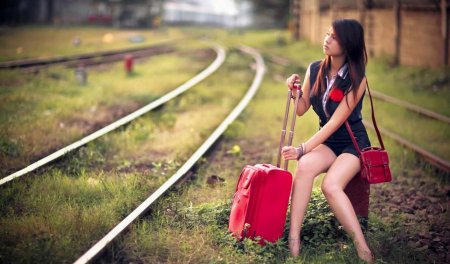 Девушка с чемоданом на дороге