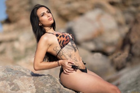 Брюнетка с татуировкой на животе