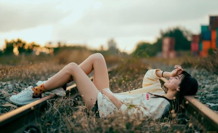 Девушка лежит на рельсах