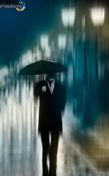 Мужчина с зонтом под дождем