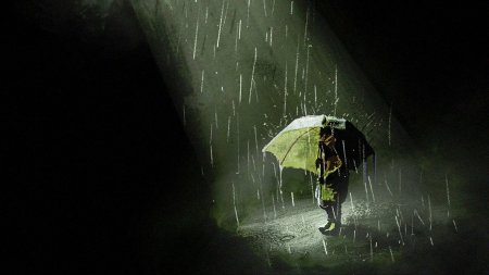 Человек с зонтом под дождем