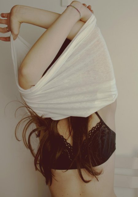 Девушка снимает майку