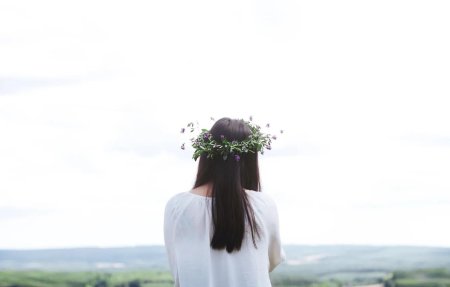 Девушка с ромашками в волосах со спины
