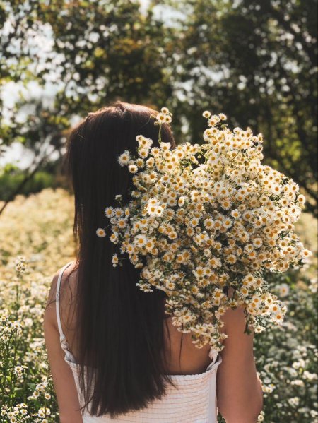 Брюнетка с букетом ромашек