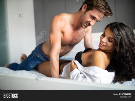 Handsome young Athletic man with bare Torso and sexy young woman in Black lingerie are kissing and hugging before having a sex