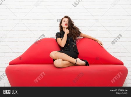 Девушка сидит на Красном диване