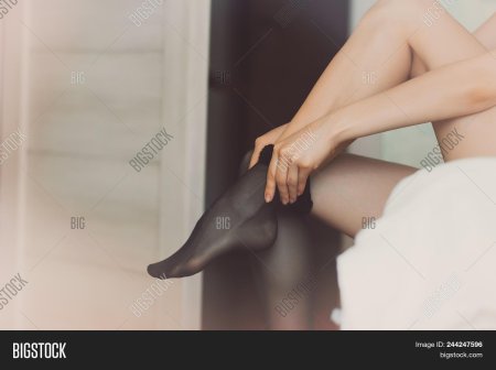 Девушка надевает чулки ню