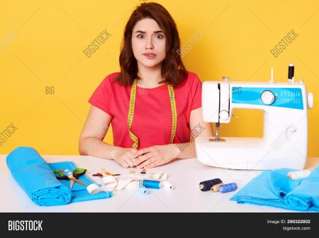 Женщина зашивает одежду за столом