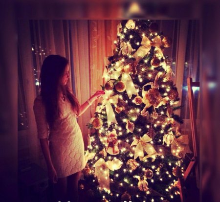 Девушка наряжает елку