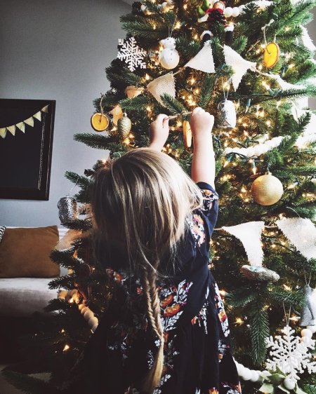 Девушка наряжает елку