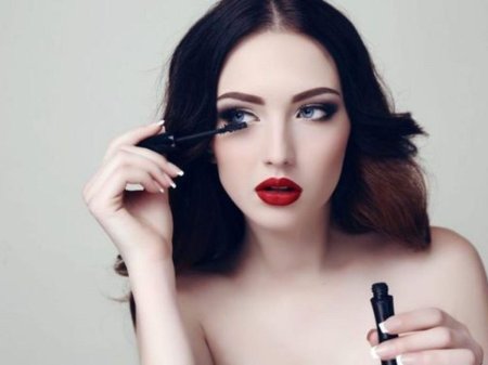 Женщина поправляет макияж фото