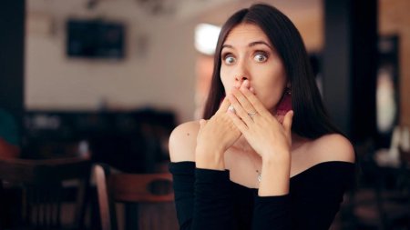 Женщина закрывает рот рукой