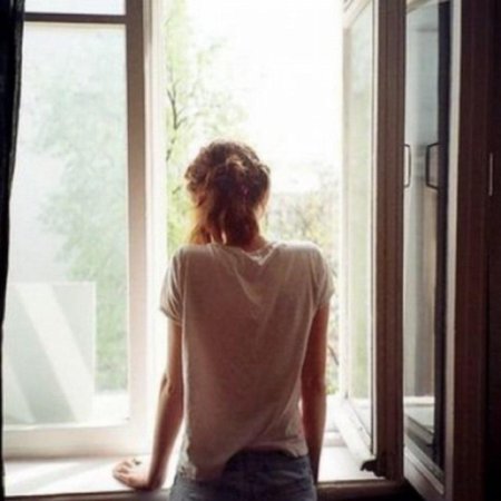 Девушка у окна со спины