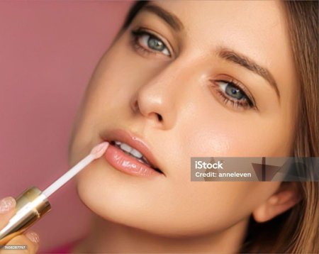 Девушка красит губы блеском