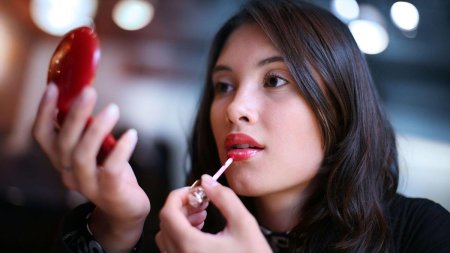 Женщина красит губы