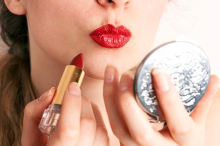 Девушка красит губы