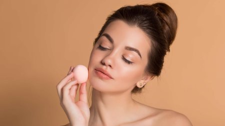 Девушка наносит крем на лицо