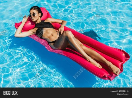 Девушка на матрасе в бассейне