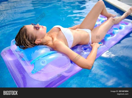 Девушка загорает на матрасе