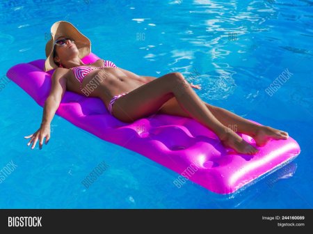 Девушка загорает на матрасе
