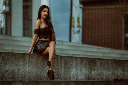 Женщина сидит с высоко поднятой мини- юбкой