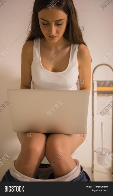 Девушка сидит на унитазе