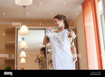 Девушка держит платье