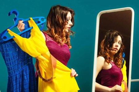 Женщина примеряет платье