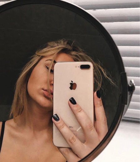 Девушка с айфоном в зеркале