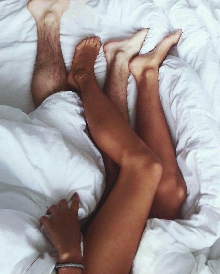 Мужские и женские ноги в кровати