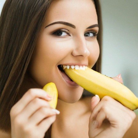 Девушка ест банан