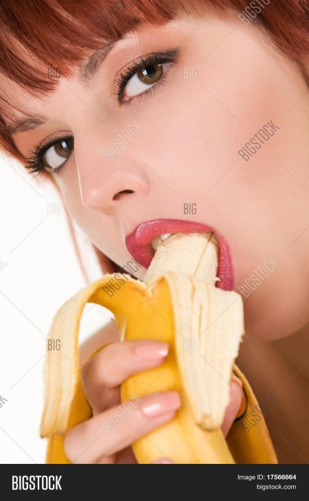 Девушка кушает банан